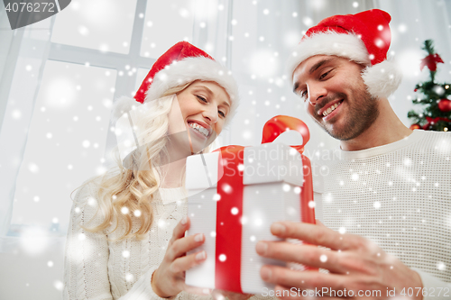 Image of happy couple at home with christmas gift box