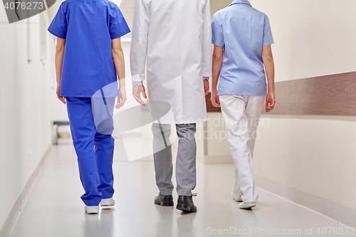 Image of group of medics or doctors walking along hospital