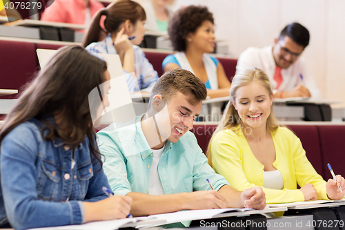 Image of group of students with notebooks in lecture hall