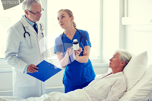 Image of doctor giving medicine to senior woman at hospital