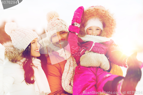 Image of happy family with child in winter clothes outdoors
