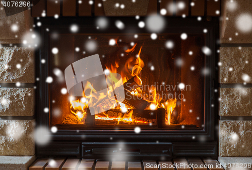 Image of close up of burning fireplace with snow