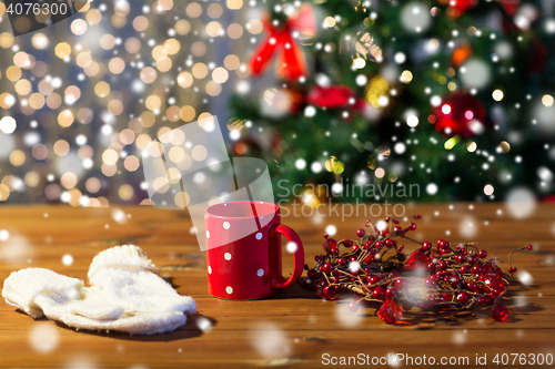 Image of tea cup with mittens and christmas decoration