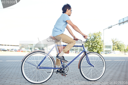 Image of young hipster man riding fixed gear bike