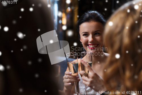 Image of happy women with champagne glasses at night club