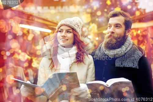 Image of happy couple with map and city guide in old town