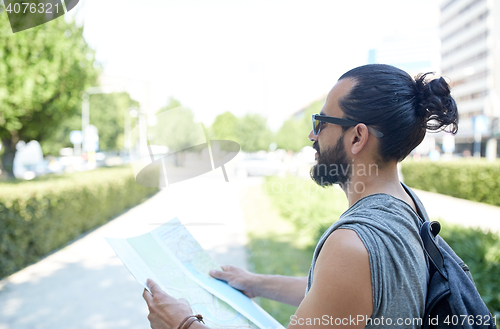 Image of close up of man with backpack and map in city