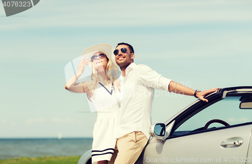 Image of happy man and woman hugging near car at sea