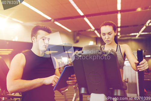 Image of woman with trainer exercising on stepper in gym