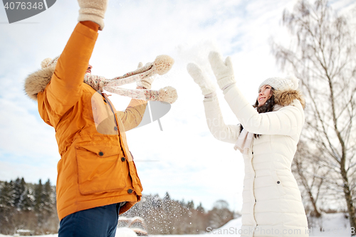 Image of happy couple playing with snow in winter