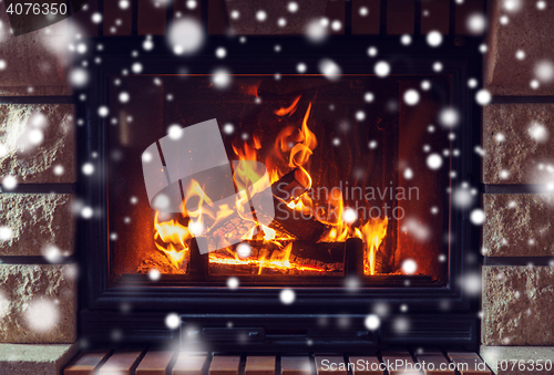 Image of close up of burning fireplace with snow