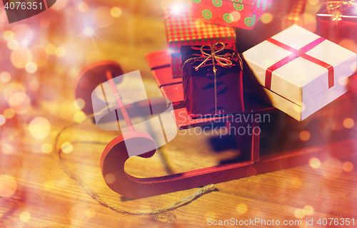 Image of close up of christmas gift boxes on wooden sleigh