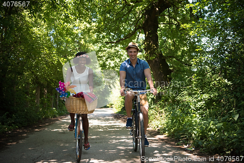 Image of Young multiethnic couple having a bike ride in nature