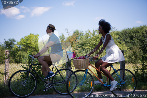 Image of Young multiethnic couple having a bike ride in nature