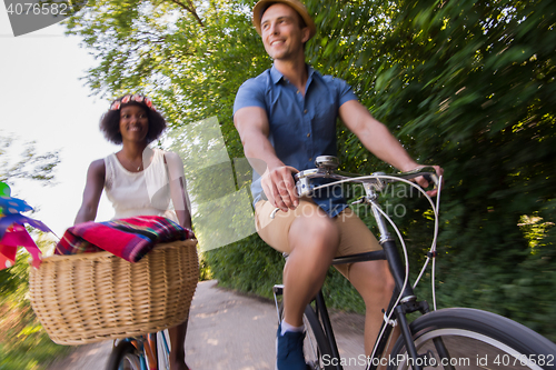 Image of Young multiethnic couple having a bike ride in nature