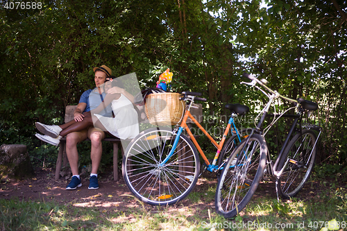 Image of Young multiethnic couple having a bike ride in nature