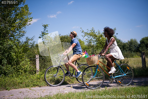 Image of Young multiethnic couple having a bike ride in nature