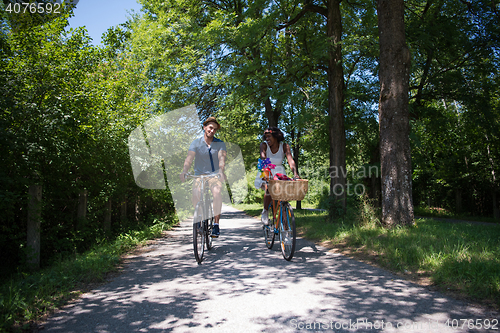 Image of Young multiethnic couple having a bike ride in nature