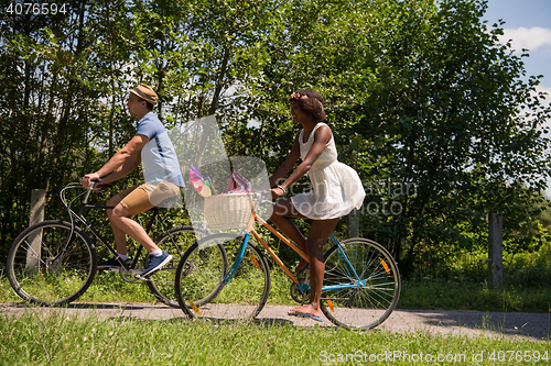 Image of Young multiethnic couple having a bike ride in nature
