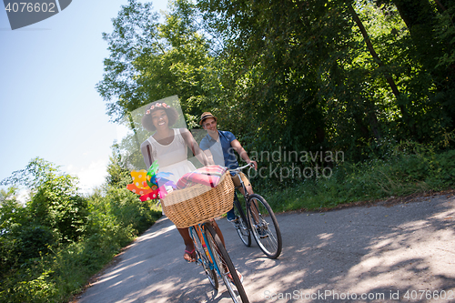 Image of Young multiethnic couple having a bike ride in nature