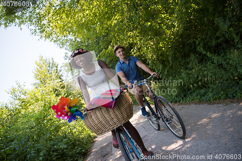 Image of Young multiethnic couple having a bike ride in nature
