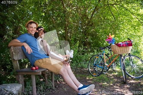 Image of Young multiethnic couple having a bike ride in nature