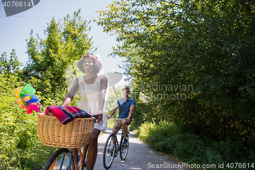 Image of Young multiethnic couple having a bike ride in nature