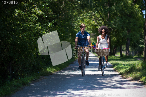 Image of Young multiethnic couple having a bike ride in nature