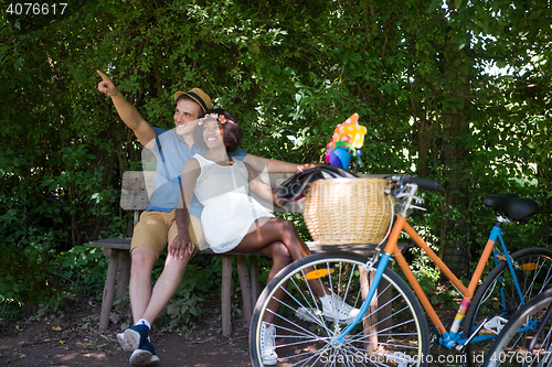 Image of Young multiethnic couple having a bike ride in nature