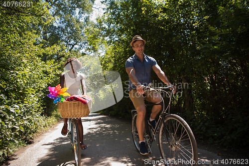 Image of Young multiethnic couple having a bike ride in nature