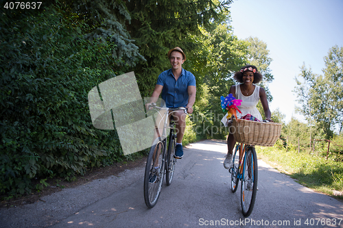 Image of Young multiethnic couple having a bike ride in nature