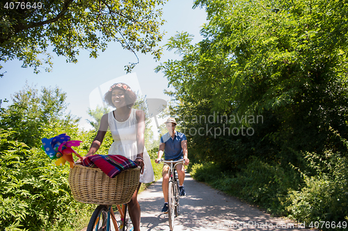 Image of Young multiethnic couple having a bike ride in nature
