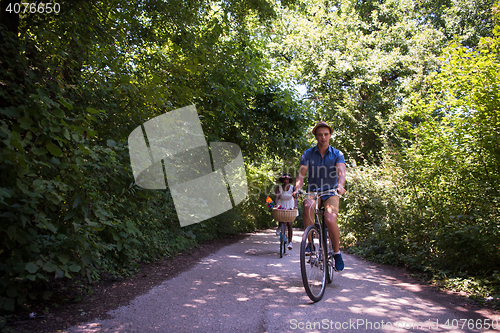 Image of Young multiethnic couple having a bike ride in nature
