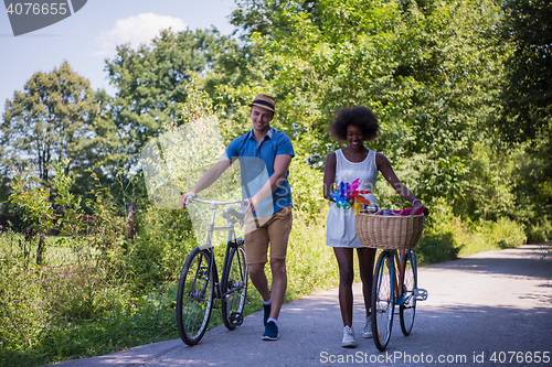 Image of Young multiethnic couple having a bike ride in nature