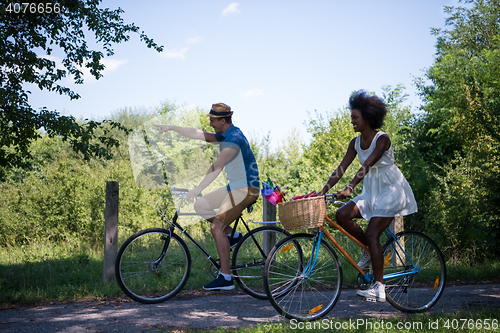 Image of Young multiethnic couple having a bike ride in nature