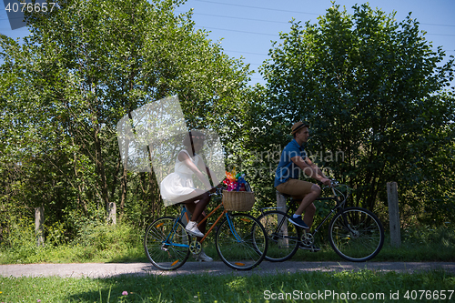 Image of Young multiethnic couple having a bike ride in nature