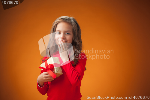 Image of The cute cheerful little girl on orange background
