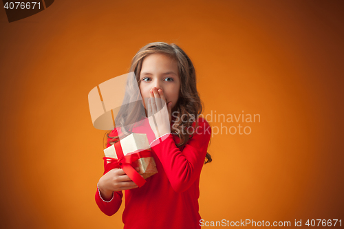 Image of The cute cheerful little girl on orange background