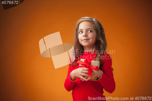 Image of The cute cheerful little girl on orange background