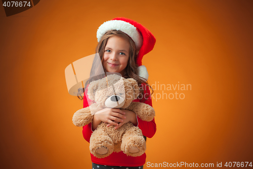 Image of The cute cheerful little girl on orange background