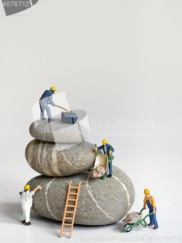 Image of Pebbles stack and figurines of construction 