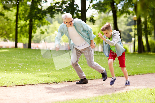 Image of grandfather and grandson racing at summer park