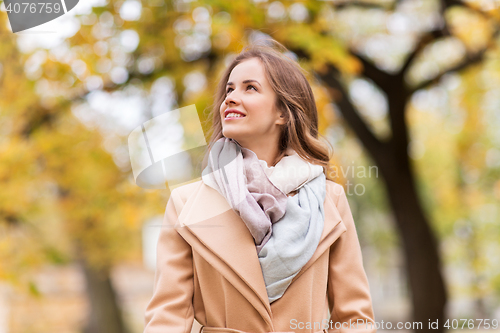 Image of beautiful happy young woman walking in autumn park