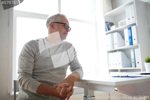 Image of senior man sitting at medical office table