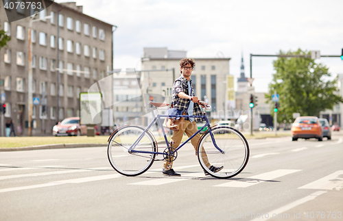 Image of young man with fixed gear bicycle on crosswalk