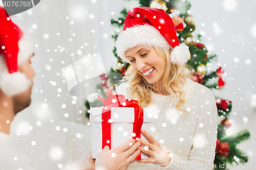 Image of happy couple at home with christmas gift box