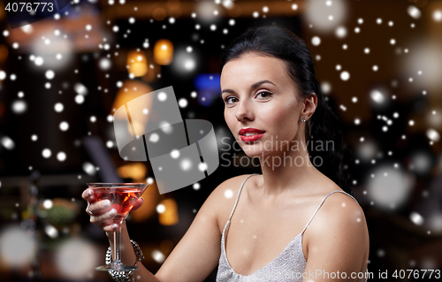 Image of glamorous woman with cocktail at night club or bar