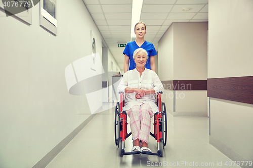 Image of nurse with senior woman in wheelchair at hospital