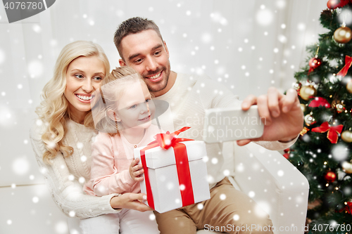 Image of family taking selfie with smartphone at christmas