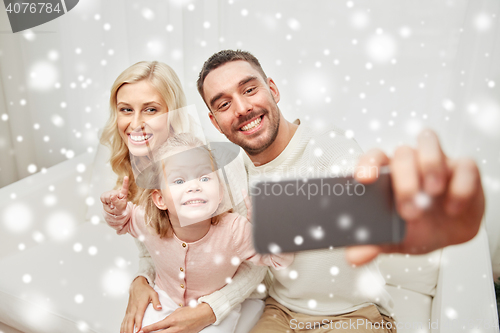 Image of family taking selfie with smartphone at home